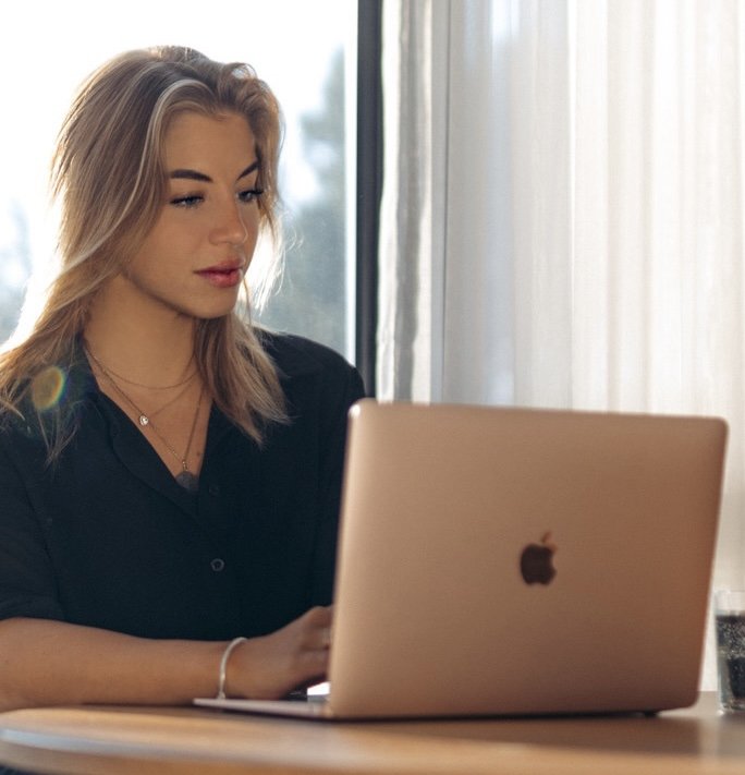 Bianca Polizzi, Head of Marketing at Blank Canvas Hospitality Group, working on a laptop